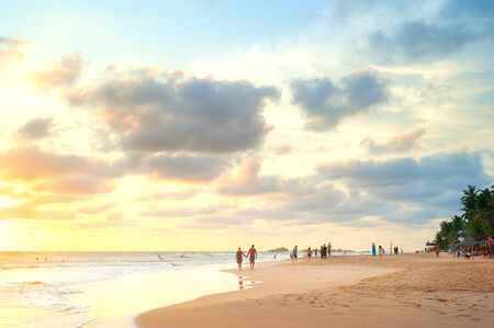 People walking on the beach of Sri Lanka at sunsetの写真素材