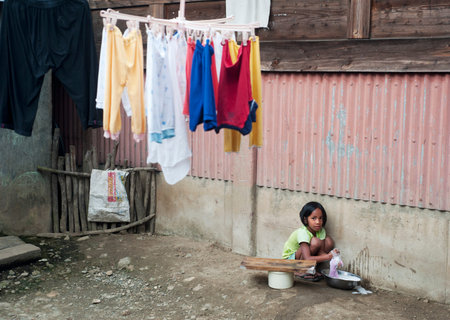 AGADA, PHILIPPINES - MARCH 23, 2012: Girl washing clothes in the small village in Philippines. About 12 per cent of Philippines children between the ages of five and 14 are forced to work. のeditorial素材