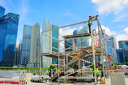 SINGAPORE - MAY 09, 2013: Workers at construction site in front of Singapore downtown in Singapore. Construction industry is expected to pull in some $30 billion this yearのeditorial素材