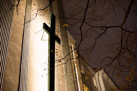 Cross on the church wall at night. Berlin, Germanyの写真素材