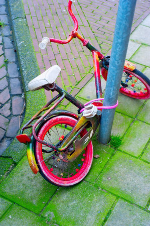 Old child bicycle at a parking. Amsterdam, Netherlandsの写真素材