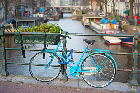 Blue bycicle on the bridge in Amsterdam, Netherlandsの写真素材