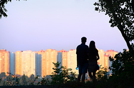 Silhouette of couple in the park in front of city skylineの写真素材