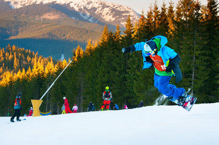 BUKOVEL, UKRAINE - DEC 08, 2015: Snowboarder jumping in Bukovel ski resort. Bukovel is the most...