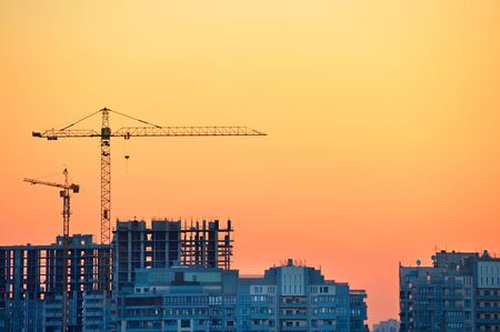 Cranes at construction site in the colorful sunsetの写真素材