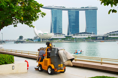 SINGAPORE - JAN 14, 2017: Cleaning car and boat in front of Marina Bay in Singapore. Singapore is a global commerce, finance and transport hub.のeditorial素材