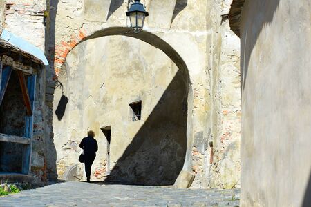 Silhouette of a woman walking at Sighisoara Old Town. Romaniaの写真素材