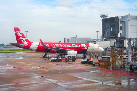 SINGAPORE - FEB 15, 2017: AirAsia aircraft in Changi International Airport during unloading baggage. Changi is the biggest airport in the world.のeditorial素材