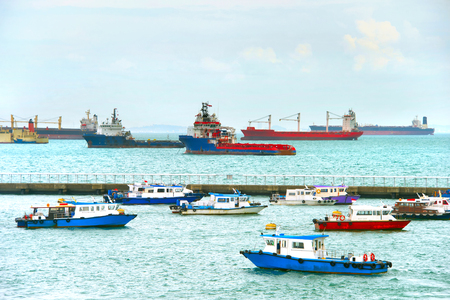 Ships and boats in Singapore harbor in the dayの写真素材