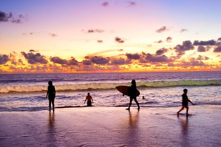 People having fun on the beach at sunset. Bali island, Indonesiaの写真素材