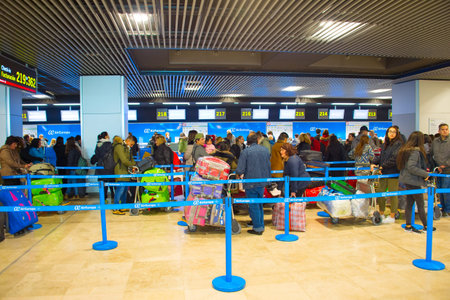 MADRID, SPAIN - DEC 26, 2016: Passangers waiting at check-in counter in Madridâ€“Barajas...