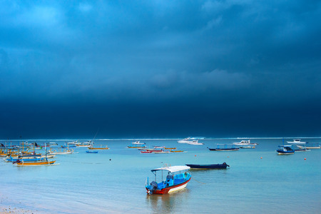 Lots of fisher boats in the ocean in the strom. Bali island, Indonesiaの写真素材