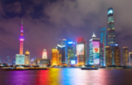 Blurred skyline of Shanghai Downtown at night with reflection in the river