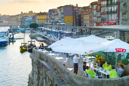 PORTO, PORTUGAL - JUNE 01, 2017: People at street reataurant on quayside of Porto. About 10 million tourist visit Portugal every year.のeditorial素材