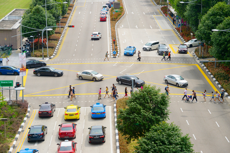 SINGAPORE - FEB 18, 2017: People crossing a road in Singapore. Singapore is a major financial, business and cultural city in Southeast Asiaのeditorial素材