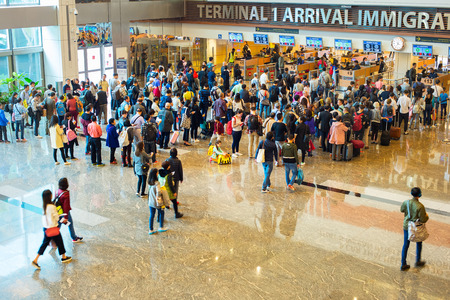 SINGAPORE - JAN 13, 2017: People waiting in queue at arrival immigration of Changi airport. Changi International Airport serves more than 100 airlines operating 6,100 weekly flights.のeditorial素材
