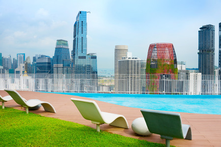Roof top deckchairs with view to Singapore Downtown. Singaporeのeditorial素材