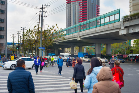 SHANGHAI, CHINA - DEC 23, 2016: People crossing the road in Downtown of Shanghai. Shanghai is one of...