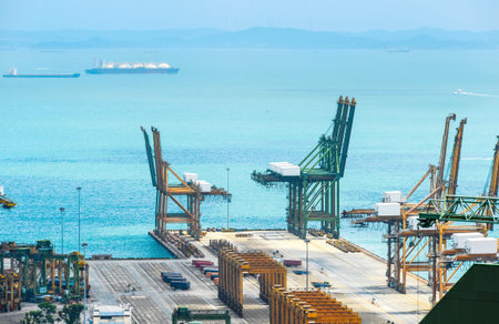 Aerial view of Singapore commercial port harbor with cranes and containers at pier, seascape with...