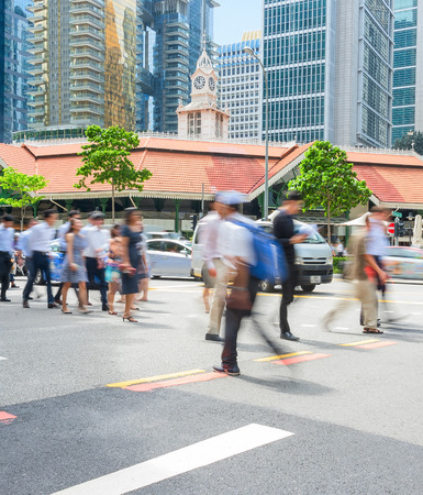 People walking by crossroad during rush hour in business center of Singaporeのeditorial素材