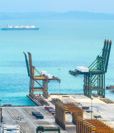 Aerial view of Singapore commercial port harbor with cranes and containers at pier, seascape with ships on backgroundのeditorial素材