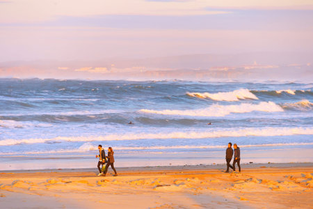 PENICHE, PORTUGAL - DECEMBER 17, 2016: Young people walking at beach by oAtlantic ocean coast in...