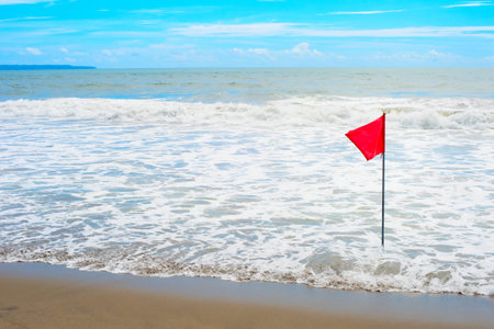 Waving red flag at the seashore, Bali, Indonesia