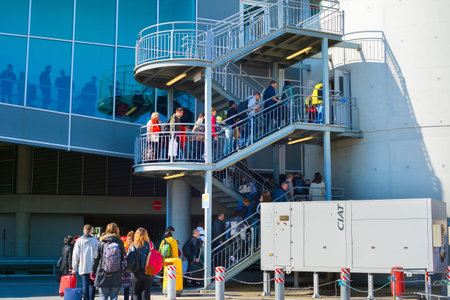 LARNACA, CYPRUS - FEBRUARY 12, 2019: People climbing up stairs with luggage to Larnaca airport terminal building, Cyprusのeditorial素材