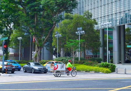 SINGAPORE - FEBRUARY 17, 2017:  Cleaning service worker riding bicycle on the road in Singapore Downtownのeditorial素材