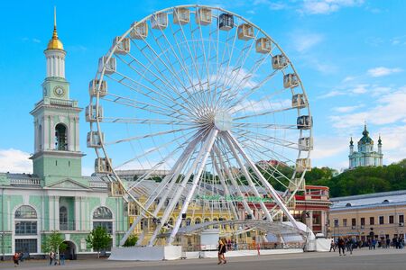 KIEV, UKRAINE - MAY 11, 2019: People walking by giant Ferries Wheel in Kiev, Ukraine. St. Andrew chuch in the backgroundのeditorial素材