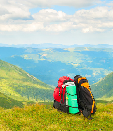 Two colorful hikers backpacks on green slope, scenic Carpathian mountains landscape in background, Ukraineの写真素材
