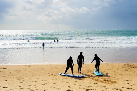 Surfing school learning taking surf lesson at the beach. Portugalの写真素材