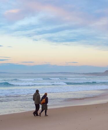 PENICHE, PORTUGAL - NOVEMBER 26, 2016: Couple walking by the Atlantic ocean beach at sunsetのeditorial素材