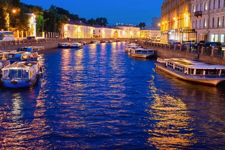 Night illuminated cityscape with boats at canal, Saint Petersburg, Russiaの写真素材