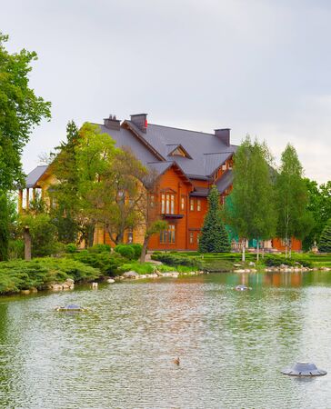 Large wooden house and pond in front. Mezhyhirya, Kiev, Ukraineのeditorial素材
