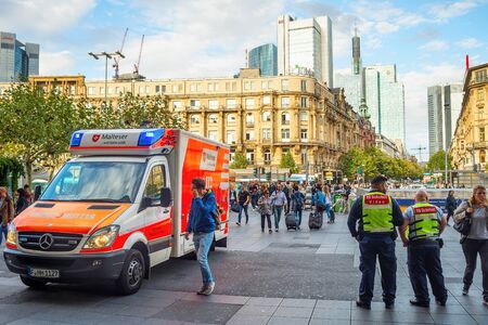 FRANKFURT, GERMANY - AUGUST 31, 2018: Central square crowded with people, emergency mobile car, skyscrapers of modern architecture, cityscape in sunset lightのeditorial素材