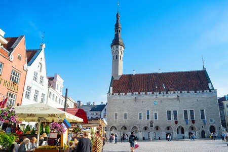 TALLINN, ESTONIA - JULY 14, 2019: Central square touristic destination of old town with cafes and restaurants decorated with flowers, church in bright sunshineのeditorial素材