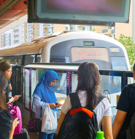 SINGAPORE - FEB 15, 2017: Passengers wating for arriving Singapore Mass Rapid Transit (MRT) train. The MRT has 102 stations and is the second-oldest metro system in Southeast Asiaのeditorial素材