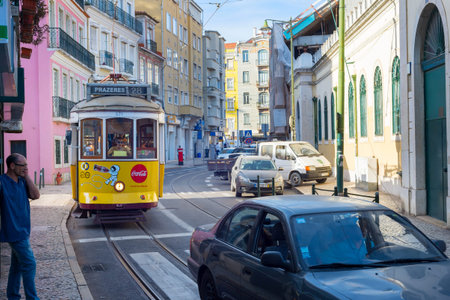 LISBON, PORTUGAL - SEPT 18, 2018: Famous old-fashioned tram 28 on a narrow Lisbon street, Portugal