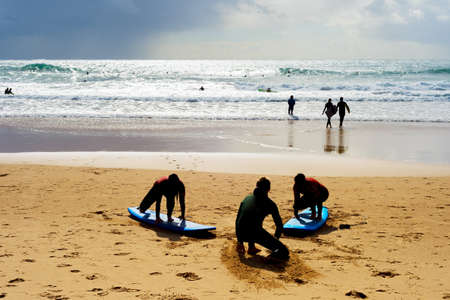 Surfing school learning taking surf lesson at the beach. Portugalの写真素材
