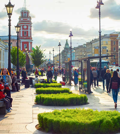 SAINT-PETERSBURG, RUSSIA - JULY 11, 2019: People walking by Gostiny dvor in evening sunlight, cars in traffic jam and sunset cityscape with classical architecture of Saint Petersburg, Russiaのeditorial素材