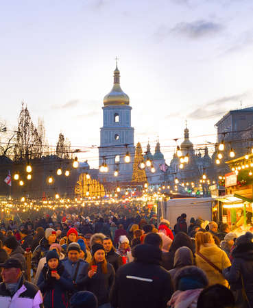 KIEV, UKRAINE - JANUARY 06, 2020: People attending New Year and Christmas market in an Old Town of Kiev, with Sophia Cathedral in the backgroundのeditorial素材