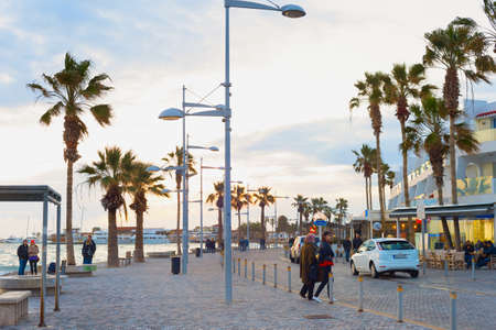 PAPHOS, CYPRUS - FEBRUARY 15, 2019: People walking by embankment at beautiful twilight in Paphosのeditorial素材