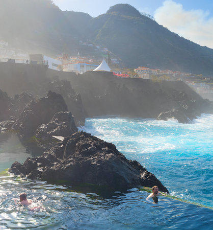 PORTO MONIZ, MADEIRA, PORTUGAL - FEB 03, 2020: People bathes in natural lava ocean pools. Lava pools are the main attraction of Madeira.のeditorial素材