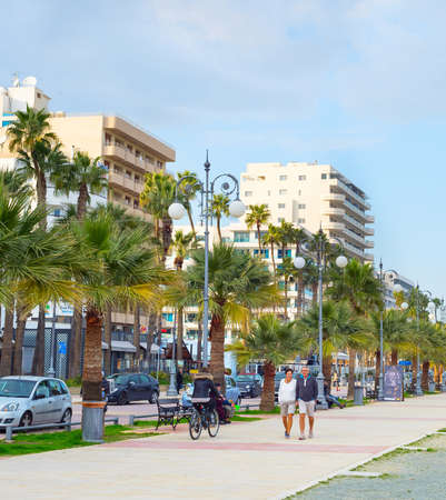LARNAKA, CYPRUS - FEB 18, 2019: People walking by Larnaca city embankment with typical architecture buildings in bright sunshine day. Cyprusのeditorial素材