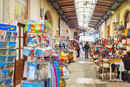 PAPHOS, CYPRUS - FEBRUARY 16, 2019: Colorful gifts magnets, kitchen towels on stands at souvenir market in Larnaca touristic downtownのeditorial素材
