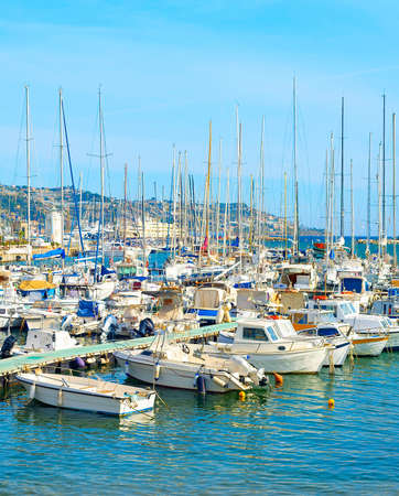 Motorbats and yachts moored in marina of coastal town, sunny day, Italyの写真素材