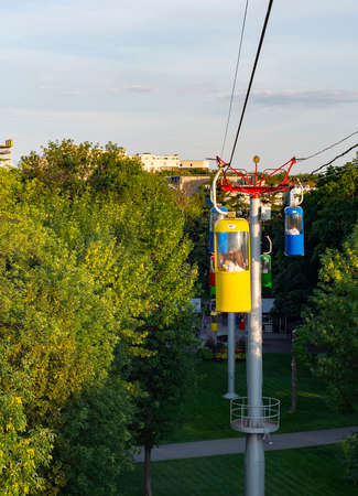 Sunset light, cable way over park green trees, Kharkiv citycsape in background, Ukraineの写真素材