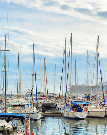 Marina with moored luxuary yachts, cruise ship in background, overcast sky. Sanremo, Italyの写真素材