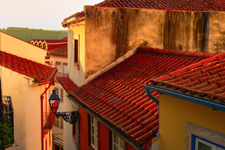 Narrow street with traditional architecture in susnet light, red rooftops, vintage lantern, Porto, Portugalの写真素材